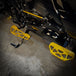 TC Bros. Pro Series MX Slim Floorboards for Harley Davidson Bagger Touring Models feature a skeletal design with metal pins, resembling high-performance pedals in silver, black, and gold. Arranged diagonally, they offer a striking visual appeal.