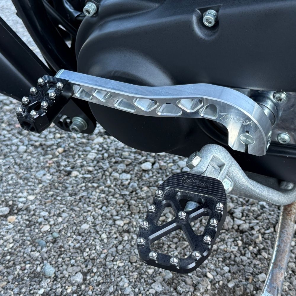 Two billet aluminum TC Bros. Pro Series Truss Shift Levers for 1991-2017 Harley-Davidson Dyna, one black and one silver, with cutout geometric patterns, are displayed on a white background—perfect for your next CNC machined upgrade.