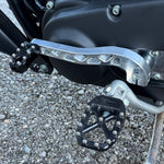 Two billet aluminum TC Bros. Pro Series Truss Shift Levers for 1991-2017 Harley-Davidson Dyna, one black and one silver, with cutout geometric patterns, are displayed on a white background—perfect for your next CNC machined upgrade.