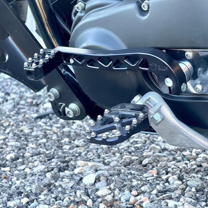 Two billet aluminum TC Bros. Pro Series Truss Shift Levers for 1991-2017 Harley-Davidson Dyna, one black and one silver, with cutout geometric patterns, are displayed on a white background—perfect for your next CNC machined upgrade.