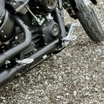 The TC Bros. Pro Series Truss Brake Arm is a 6061-T6 aluminum upgrade for 2018-up Harley-Davidson Softail brake pedals, featuring triangular cutouts and a circular mounting hole—available in silver or black.