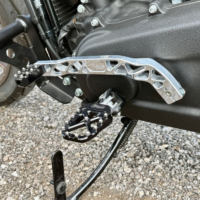 The TC Bros. Pro Series Truss Shift Lever for 2018-Up Harley-Davidson M8 Softail features silver and black metal lever arms with geometric cut-outs and "TC Bros." engraving—ideal for your Softail upgrade.