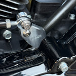 Two metal brackets, one silver and one black, each with a matching screw and bolt, displayed on a white background. Text reads "TC Bros. Pro Series Easy Shift Lever Extension for Harley-Davidson Big Twin—Milwaukee-Eight.