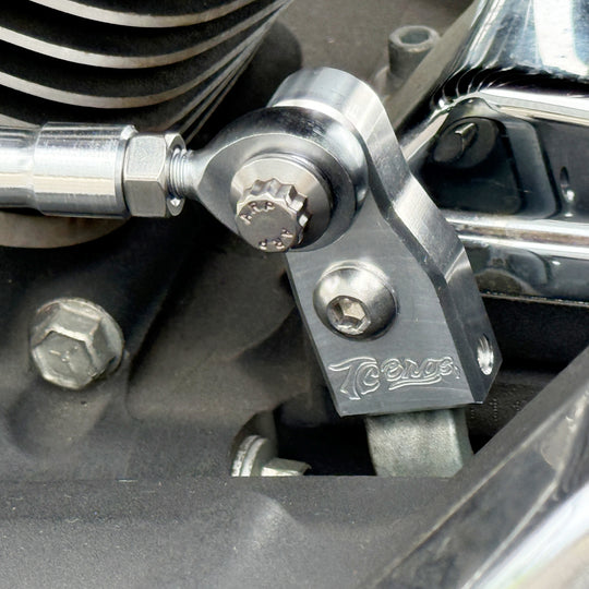 The TC Bros. Pro Series Easy Shift Lever Extension for Harley-Davidson Big Twin—Twin Cam includes silver and black metal brackets with threaded holes, engraved logos, and screws. Fits Touring, Dyna, and Softail models.