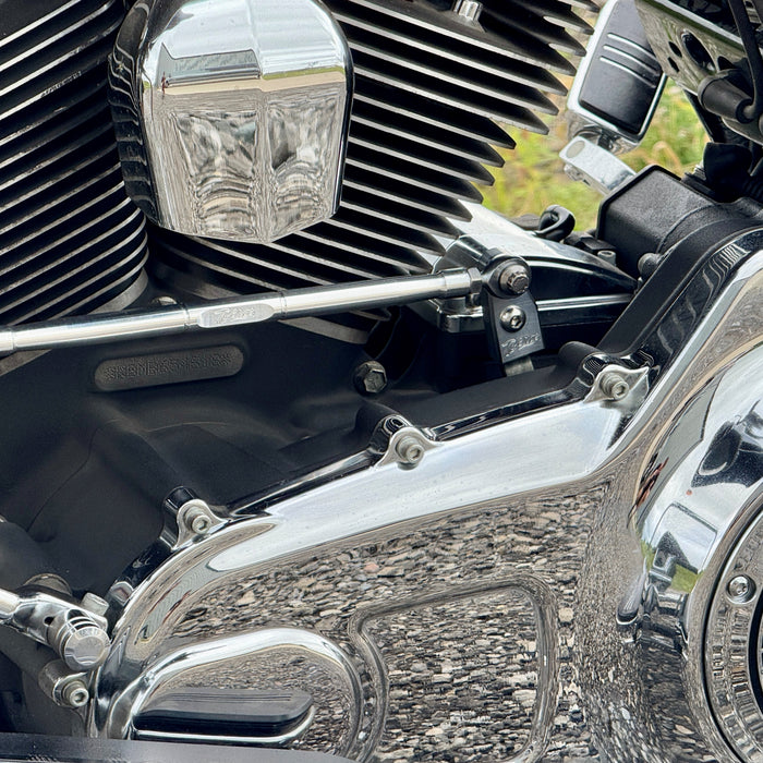 The TC Bros. Pro Series Easy Shift Lever Extension for Harley-Davidson Big Twin—Twin Cam includes silver and black metal brackets with threaded holes, engraved logos, and screws. Fits Touring, Dyna, and Softail models.