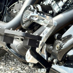 The TC Bros. Pro Series Truss Brake Pedal Arm for 2014-Up Harley-Davidson Touring is shown here in disassembled form, including the black metal pedal arm, matching mounting bracket, and a single screw—all displayed against a white background. Perfect for customizing your Touring/Bagger motorcycle or upgrading your Harley-Davidson with this adjustable brake lever setup from TC Bros.