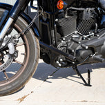 The TC Bros. Front Crash Bar for Harley-Davidson M-8 Softail w/ Mid Controls is a black metal engine guard, shown with mounting hardware—bolts, washers, spacers, and brackets—ideal for added protection on your Softail.