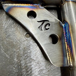 Two black metal TC Bros. Rear Saddlebag Guards with mounting holes, four bolts, two nuts, and four rubber grommets are arranged on a white background—essential components from TC Bros. for installing rear saddlebag guards on 2009-up Harley-Davidson Touring models to enhance rear crash protection.