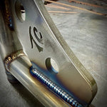 Two black metal TC Bros. Rear Saddlebag Guards with mounting holes, four bolts, two nuts, and four rubber grommets are arranged on a white background—essential components from TC Bros. for installing rear saddlebag guards on 2009-up Harley-Davidson Touring models to enhance rear crash protection.