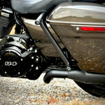 Two black metal TC Bros. Rear Saddlebag Guards with mounting holes, four bolts, two nuts, and four rubber grommets are arranged on a white background—essential components from TC Bros. for installing rear saddlebag guards on 2009-up Harley-Davidson Touring models to enhance rear crash protection.