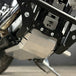 The TC Bros. Skid Plate for Harley-Davidson Sportster 2004-2022 includes black and silver aluminum plates with cut-out logos and mounting hardware, offering added engine protection.