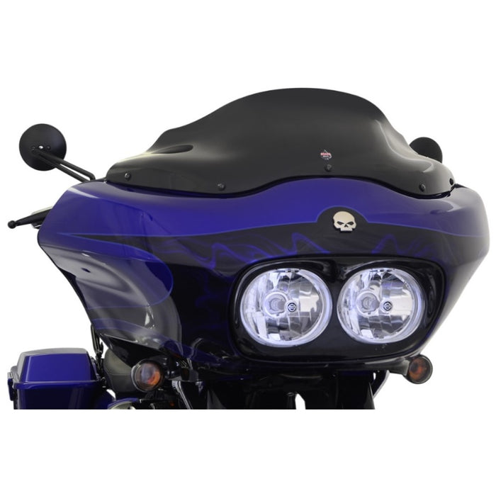 Close-up view of a blue motorcycle with a skull emblem on the front fairing, featuring twin headlights and black handlebars, equipped with a Klockwerks Flare Windshield - 8" - Black - For 1998-2013 FLTR.