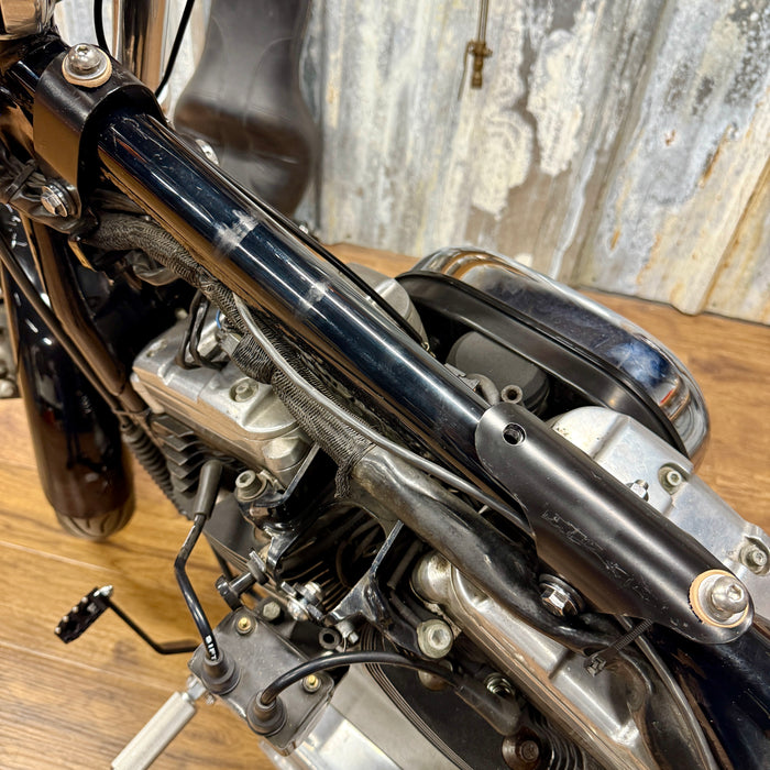 The TC Bros. Frisco Gas Tank Adapter Brackets set for 1982-2003 Harley-Davidson Sportster includes black metal brackets, bolts, washers, nuts, and rubber grommets—perfect for tongue-mount fuel tank installations.