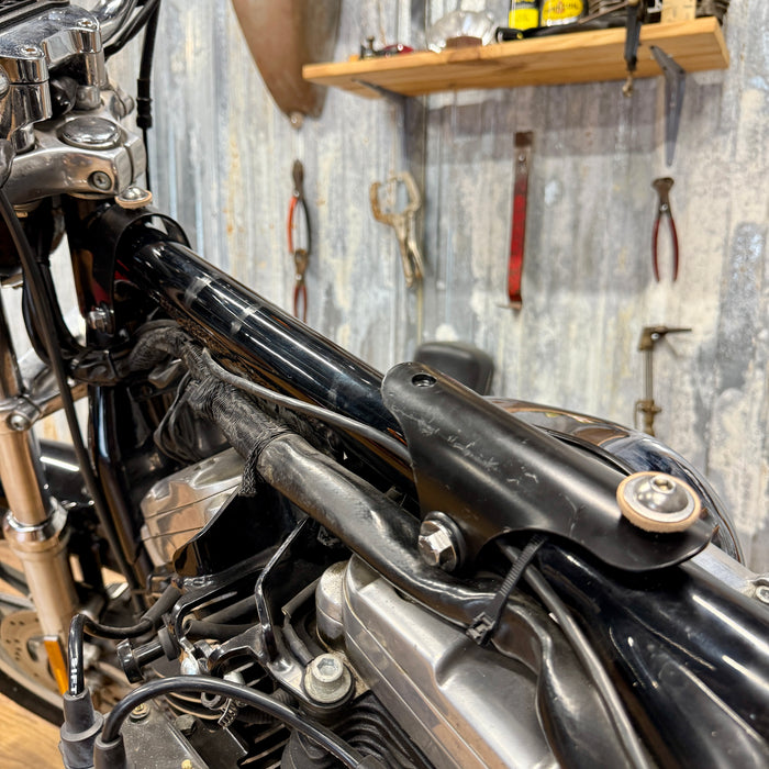 The TC Bros. Frisco Gas Tank Adapter Brackets set for 1982-2003 Harley-Davidson Sportster includes black metal brackets, bolts, washers, nuts, and rubber grommets—perfect for tongue-mount fuel tank installations.