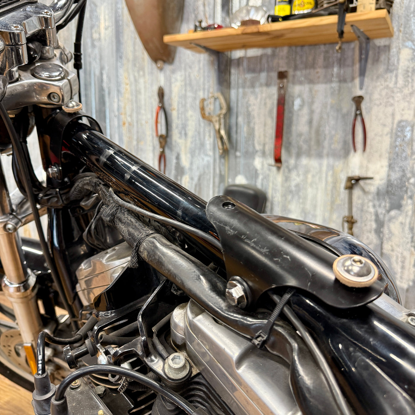 The TC Bros. Frisco Gas Tank Adapter Brackets set for 1982-2003 Harley-Davidson Sportster includes black metal brackets, bolts, washers, nuts, and rubber grommets—perfect for tongue-mount fuel tank installations.