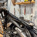 The TC Bros. Frisco Gas Tank Adapter Brackets set for 1982-2003 Harley-Davidson Sportster includes black metal brackets, bolts, washers, nuts, and rubber grommets—perfect for tongue-mount fuel tank installations.