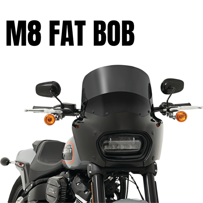 Front view of a black Harley-Davidson Fat Bob (2018-2023) with windshield, mirrors, and orange turn signals. Large "M8 FAT BOB" text above. Enhance wind protection with the Memphis Shades Road Warrior Fairing by Memphis Shades.