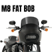 Front view of a black Harley-Davidson Fat Bob (2018-2023) with windshield, mirrors, and orange turn signals. Large "M8 FAT BOB" text above. Enhance wind protection with the Memphis Shades Road Warrior Fairing by Memphis Shades.