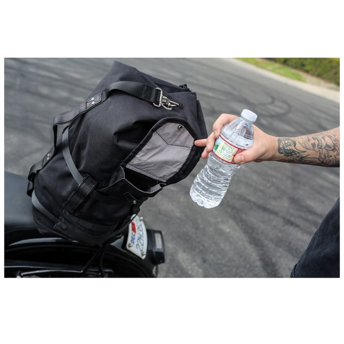 The Burly Voyager Motorcycle Sissy Bar Backpack by Burly is available in black and crafted from durable Black Cordura. It features multiple compartments, a buckled front pocket, and additional side handles. The backpack is also equipped with a MOLLE system for versatile attachment options.