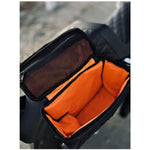 Introducing the Speedwell Cutaway Saddlebags for Harley Sportsters, M8 Softail, and Dyna—an elegant black saddlebag featuring dual compartments with stitched detailing and handles on each side. Expertly designed to straddle over the back of a motorcycle seat, it's the perfect accessory for your ride.