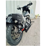 Introducing the Speedwell Cutaway Saddlebags for Harley Sportsters, M8 Softail, and Dyna—an elegant black saddlebag featuring dual compartments with stitched detailing and handles on each side. Expertly designed to straddle over the back of a motorcycle seat, it's the perfect accessory for your ride.