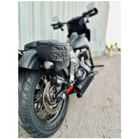 Introducing the Speedwell Cutaway Saddlebags for Harley Sportsters, M8 Softail, and Dyna—an elegant black saddlebag featuring dual compartments with stitched detailing and handles on each side. Expertly designed to straddle over the back of a motorcycle seat, it&
