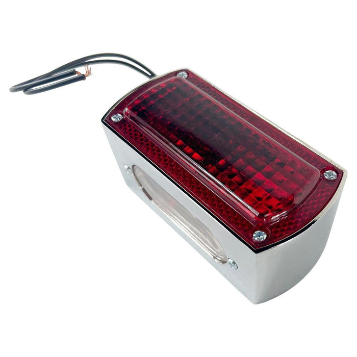 A rectangular red Box Style Chopper Tail Light with a chrome border and exposed black wires for electrical connection, reminiscent of a design by Wyatt Gatling.