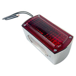 A rectangular red Box Style Chopper Tail Light with a chrome border and exposed black wires for electrical connection, reminiscent of a design by Wyatt Gatling.