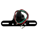 The Mid-USA Vintage Drilled Tail Light by Mid-USA features a round red lens in an aluminum housing, mounted on a black bracket with exposed electrical wires at the back.