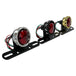 The Mid-USA Vintage Drilled Tail Light by Mid-USA features a round red lens in an aluminum housing, mounted on a black bracket with exposed electrical wires at the back.