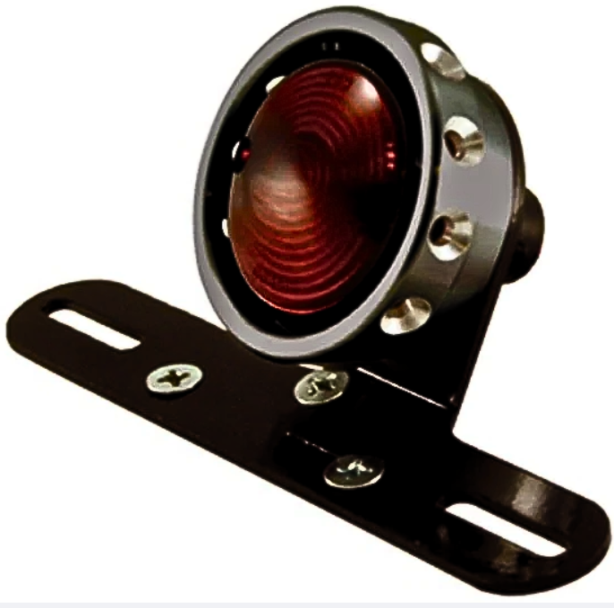 The Mid-USA Vintage Drilled Tail Light features a round design with a red lens and aluminum housing in silver, black, or gold. Each mounts on a black bracket with two screw holes and works with a 12V dual-filament bulb for reliable performance.