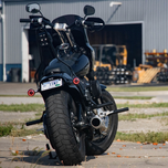A Moto Iron® LED Turn Signal Conversion Kit for 2000-2024 Harley-Davidson bikes, featuring round modules, black and white covers, adapters, and mounting plates—neatly arranged in rows on a white background.
