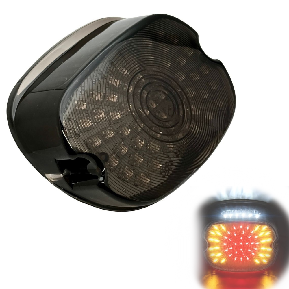A close-up of the Moto Iron® LED Laydown Squareback Light for 1973-2024 Harley-Davidson, showcasing its dark, rounded design with a smoked lens and integrated turn signals.