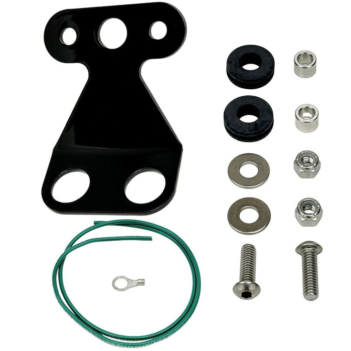 The TC Bros. Tail Light Bracket Conversion Kit includes a metal license plate bracket, green wire with ring terminal, two black rubber grommets, washers, bolts, and nuts—all from TC Bros.—arranged on a white background.