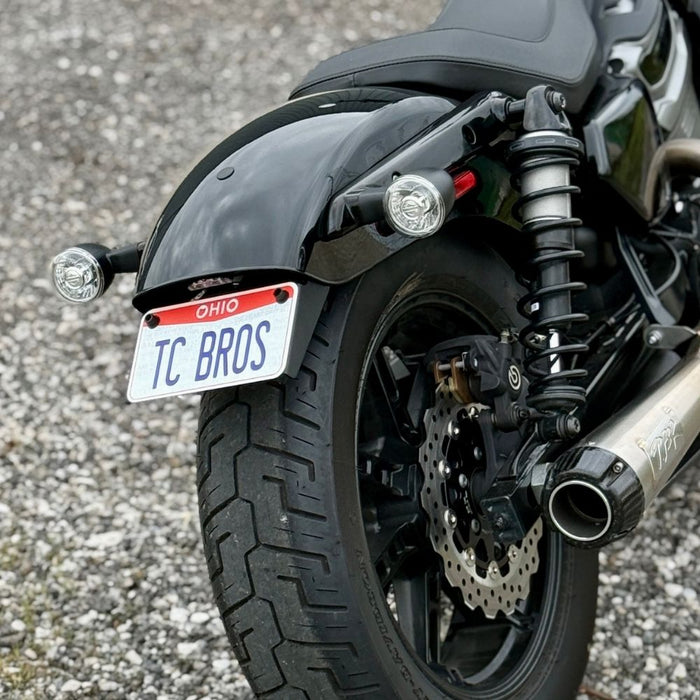 TC Bros. License Plate Relocation Bracket for 2022-Up Harley-Davidson Nightster RH975, with logo, includes screws, washers, nuts, bolt, and a black rectangular piece—all neatly arranged on a white background.