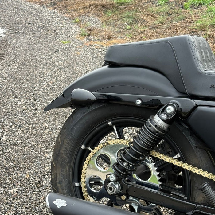 Black metal TC Bros. License Plate Relocation Bracket for 2010-2022 Harley-Davidson Sportster with mounting hardware for saddlebag installation.