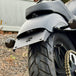 Black metal TC Bros. License Plate Relocation Bracket for 2010-2022 Harley-Davidson Sportster with mounting hardware for saddlebag installation.