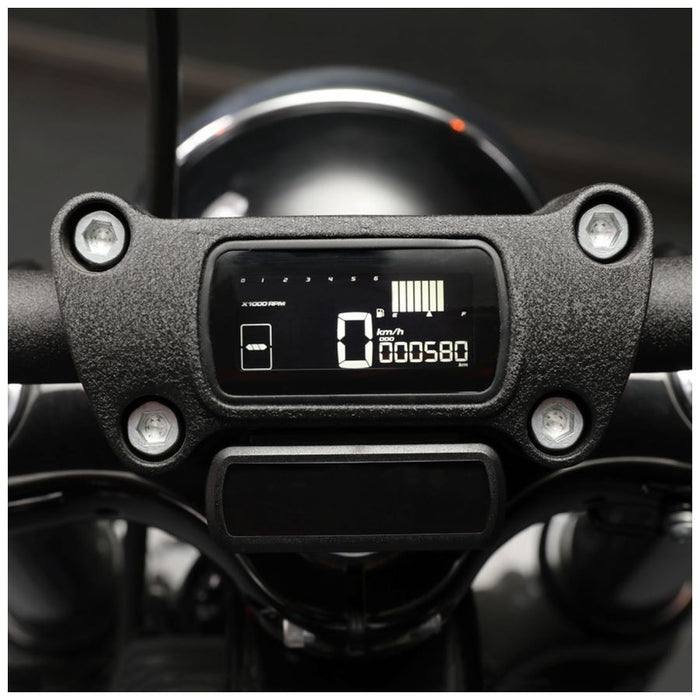 A digital car dashboard display shows a speed of 99 km/h along with engine and battery status indicators. The KOSO D2 Multifunction Meter 2018-2024 Harley M8 Softail also features a gear indicator and a programmable shift light, all branded with the Koso logo in the bottom right corner.