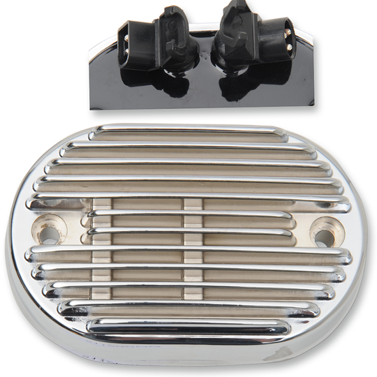 The Drag Specialties Voltage Regulator Cover for 2011-2016 Harley-Davidson Softail is an oval, metallic, vented plate with horizontal ridges and two side screw holes, designed to fit Drag Specialties voltage regulators.
