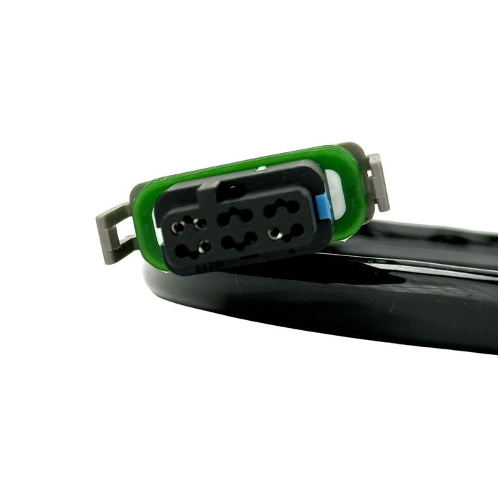 The Namz 15" Speedometer Extension/Conversion Harness for 2018-2024 Harley-Davidson Softail features a black cable with a rectangular green and black connector on one end and a small white connector on the other, coiled in a loop.