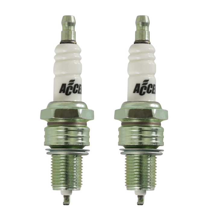 Four Accel Spark Plugs for Harley-Davidson Shovelhead and Evolution engines, from the Accel brand, are displayed in two pairs on a white background, showing noticeable differences in their metal tips.
