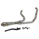 A custom SP Concepts Lane Splitter Exhaust for Harley-Davidson Dyna 1999-2005 lies on a workbench with welded joints; an American flag welding helmet is visible in the background. Stainless construction, ideal for exhaust builds.
