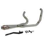 A custom SP Concepts Lane Splitter Exhaust for Harley-Davidson Dyna 1999-2005 lies on a workbench with welded joints; an American flag welding helmet is visible in the background. Stainless construction, ideal for exhaust builds.