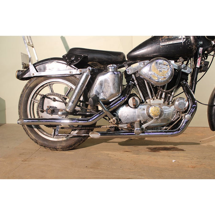 An MCM Sportster Drag Pipe Set w/Heat Shields - 1957-84 Ironhead Models is parked in a garage.