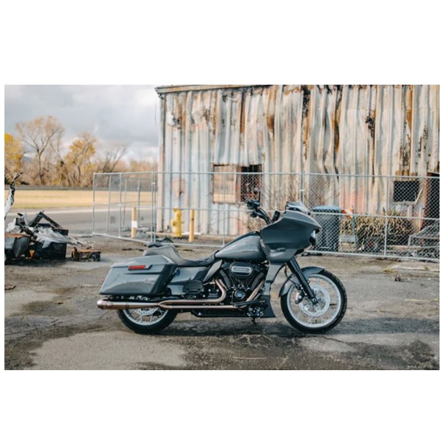 The SP Concepts Full Length Turnpike Works Edition for Harley '17-'24 M8 Touring headers and exhaust pipes made of stainless steel are neatly arranged on the warehouse floor, surrounded by shelves and boxes in the background.