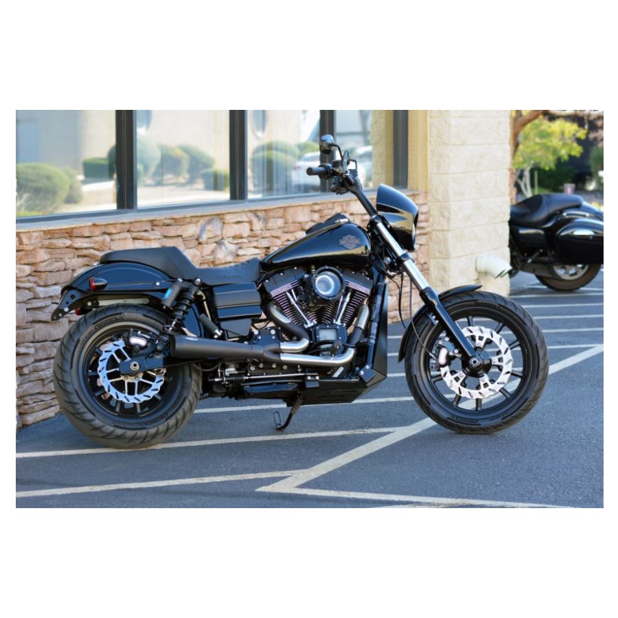 The Assault Charge High-Flow Air Cleaner, designed for Harley '08-'17 FL and '16-'17 FX models, features a cylindrical black metallic housing with a visible red filter material. The high-capacity air filter, branded "Trask," ensures optimal performance enhancement for your ride.