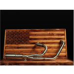 The Fab 28 Stainless Exhaust for 1999-2017 Harley-Davidson Dyna is mounted on a wooden American flag display, showcasing a bold dragon design burned into the wood.