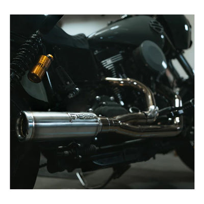 The Fab 28 Stainless Exhaust with Canister Muffler for '99-'17 Dyna Models is showcased on a wooden platform adorned with a carved American flag and a dragon design, making it an ideal choice for your bike.