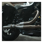 The Fab 28 Stainless Exhaust for 2017-Up Harley-Davidson Touring is shown in front of a wooden American flag with a bull design engraved on the blue field.