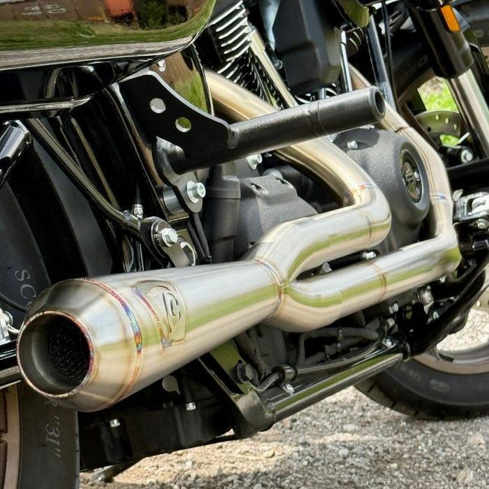 TC Bros. 2-into-1 Stainless Exhaust System for 2018-Up Harley-Davidson Softail by TC Bros., displayed with various Harley-Davidson Softail exhaust pipes in the background.